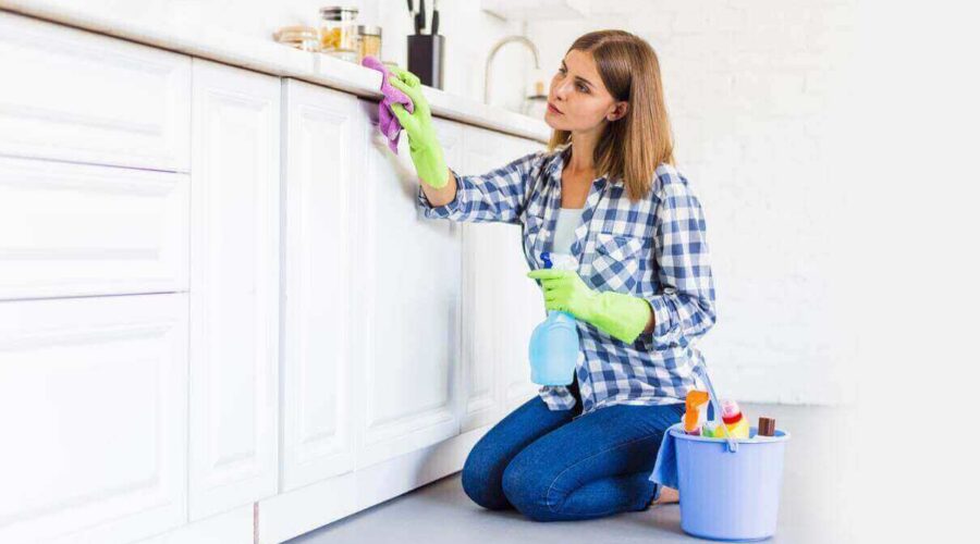 A woman from housekeeping services is cleaning the shelf
