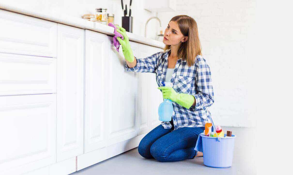 A woman from housekeeping services is cleaning the shelf