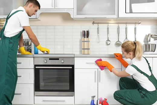 two persons from housekeeping services are cleaning kitchen